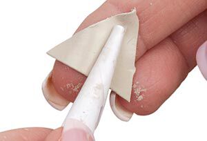 Clay triangle being wrapped over a cone